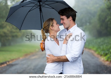 loving young couple with umbrella in the rain