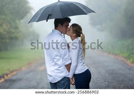loving young couple in love under umbrella in the rain