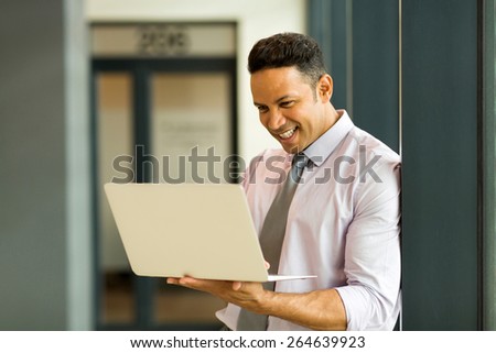 mid age office worker working on laptop in modern office