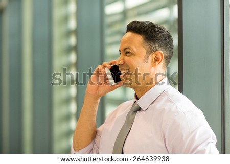 happy business executive talking on mobile phone in office