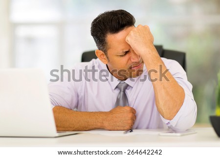 stressed middle aged businessman sitting in office