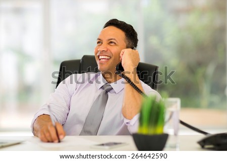 mature business man talking on landline phone in modern office
