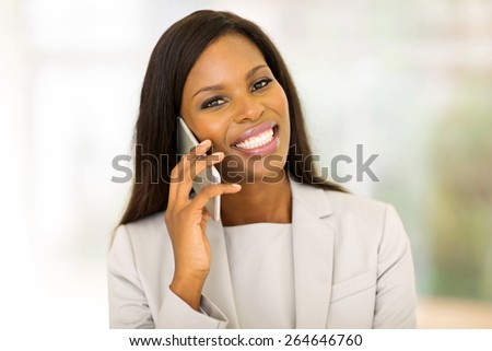 cheerful young afro american woman talking on cell phone