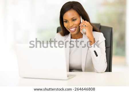 happy african american businesswoman talking on cell phone in the office