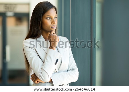 thoughtful african businesswoman looking through window