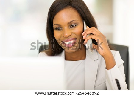 cheerful young afro american business woman talking on cell phone