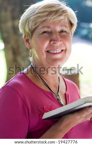 elderly woman reading bible in the garden
