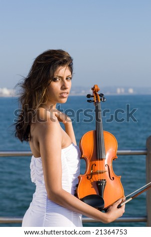 young woman play violin on beach pier