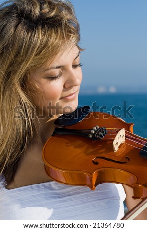 young woman play violin on beach