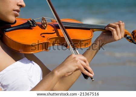 young happy indian violin player play on beach