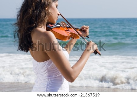 young happy indian violin player on beach