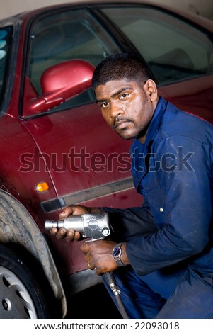 indian mechanic changing vehicle tire
