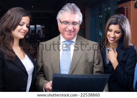 Photo of smart businessman holding paper in hand with his two young colleagues looking at it with smiles