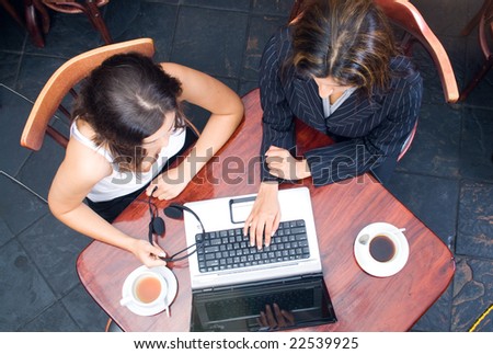 Overhead view of two business women meeting in a cafe