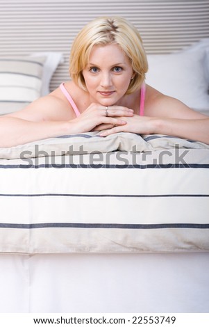 Portrait of young beautiful happy woman on bed at bedroom