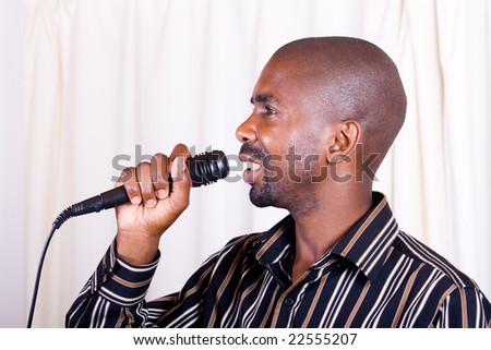 young african man singing with a microphone