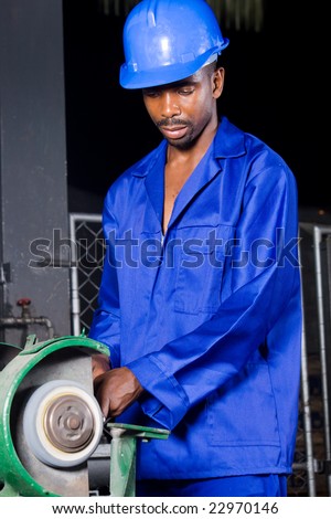 African machinist operating a grinding machine