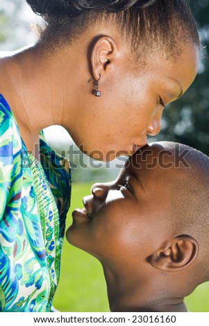 happy african mother kissing son