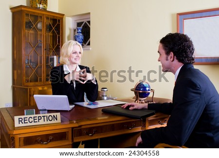 hotel manager at reception with customer