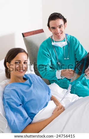 male doctor visiting his patient in the hospital ward and showing her the test result
