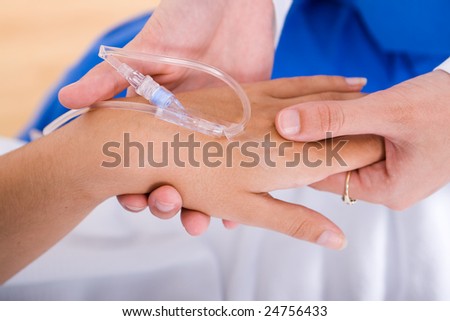nurse holding patient\'s hands with IV drips