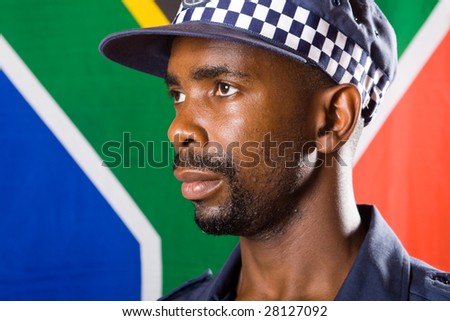 south african policeman portrait, background is south african flag