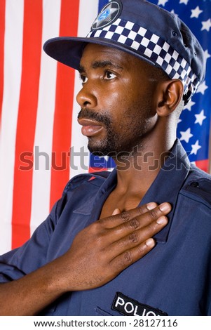 african american policeman pledging allegiance, background is USA flag