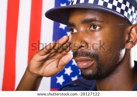 african american policeman saluting, background is USA flag