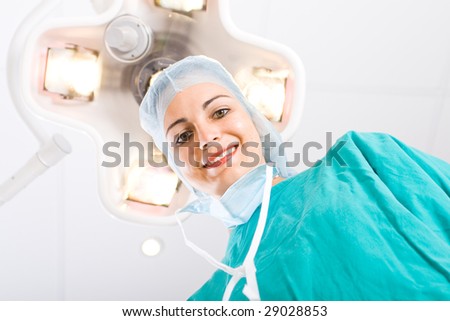 female doctor looking down at patient in operation room