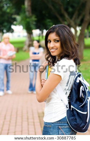 indian female college student in campus, background is her friends