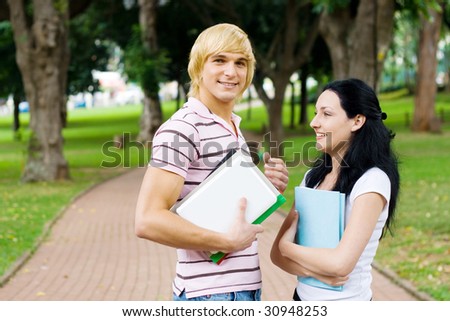 young university students chatting in campus outdoors