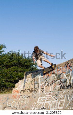 teen boy skateboarder playing on concrete ramp