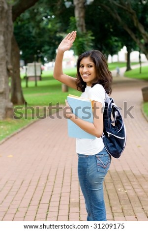 college student saying good bye and waving to her friend