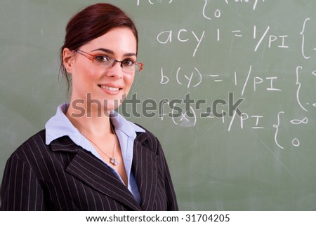 attractive female math teacher standing in front of blackboard