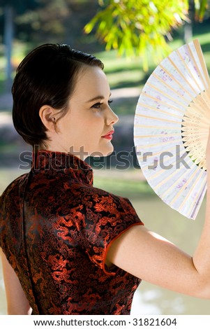 woman in traditional chinese dress and holding a chinese fan