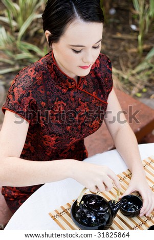 woman in chinese dress making chinese tea