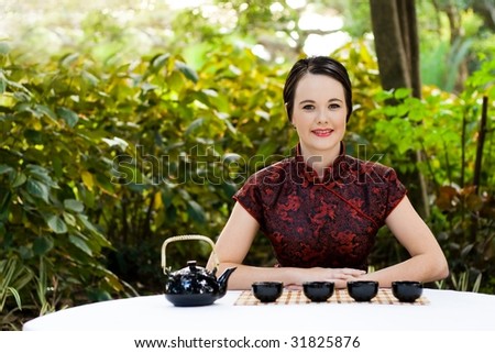 woman in chinese dress serving chinese tea