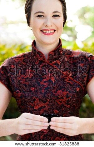 beautiful woman in chinese dress serving chinese tea