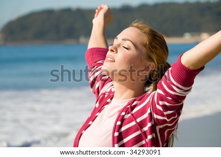 spiritual woman with arms open wide on beach