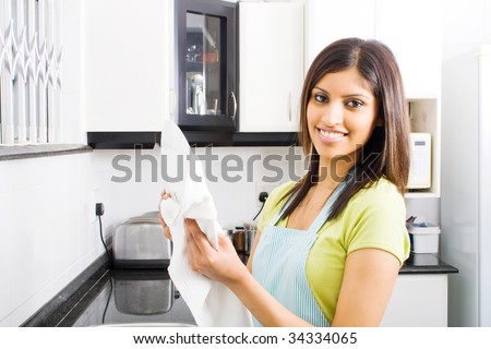 young woman drying dishes in kitchen