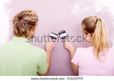 happy young couple painting new house