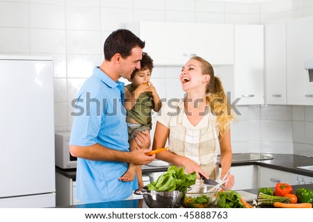 happy young family of three in home kitchen