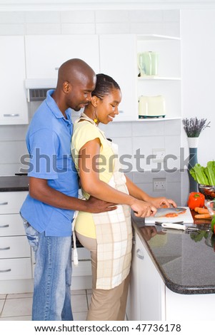 african american couple in kitchen preparing food