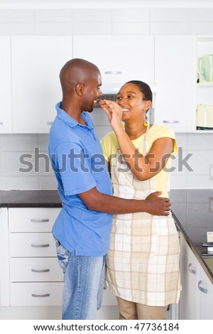 happy african american couple tasting food in kitchen