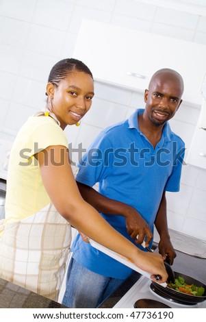 young african american couple cooking food in kitchen