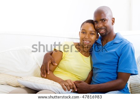 stock photo : young happy african american couple relaxing at home on sofa