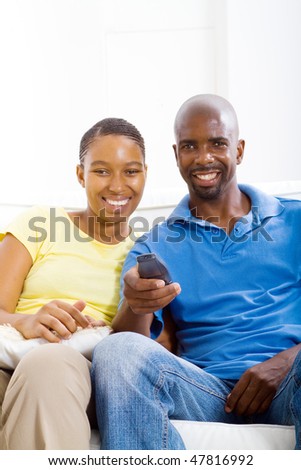 stock photo : young happy african american couple watching TV on sofa