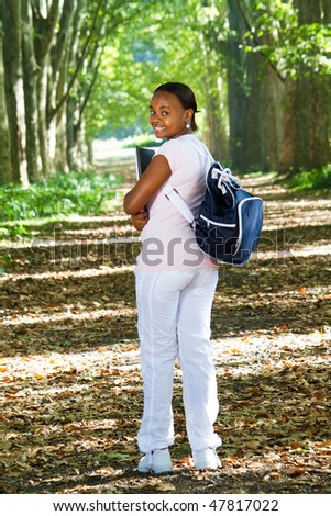 happy young african american college student in forest