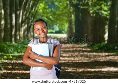 happy female african american college student in forest