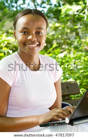 african american student studying computer outdoors